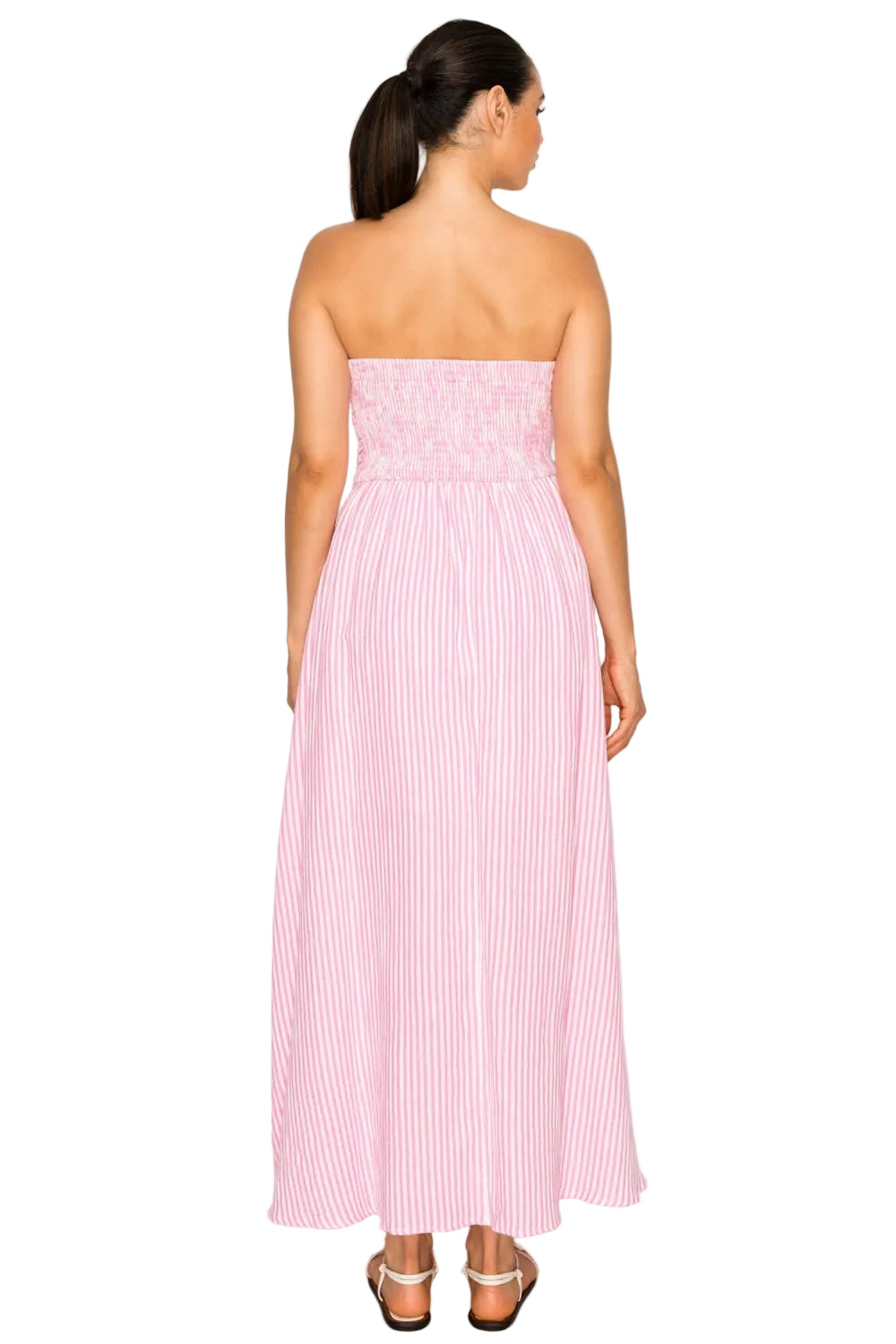 Woman wearing a pink strapless dress with white stripes on a white background