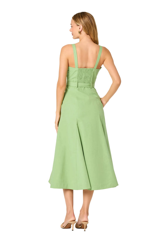 Woman wearing a light green dress with a belt on a white background