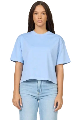 Woman wearing a light blue t-shirt and jeans on a plain background