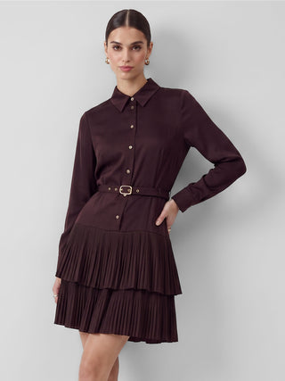 A woman wearing a belted tiered pleated mini dress in cherry lacquer with a mandarin neckline and 3/4 sleeves.