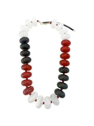 A beaded necklace with large glossy beads in red, black, and white, featuring an adjustable gold-tone clasp.