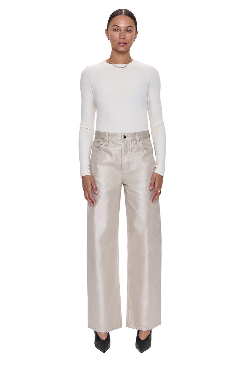 Woman wearing a white long-sleeve top and beige pants on a white background