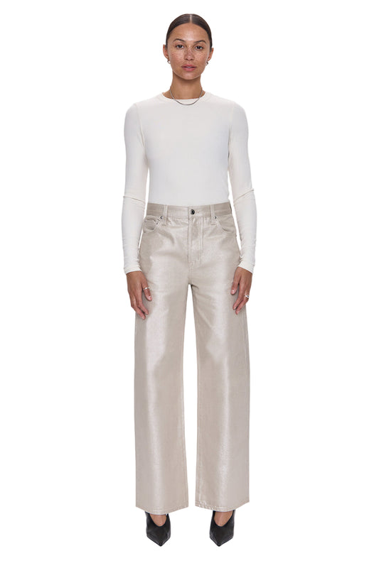 Woman wearing a white long-sleeve top and beige pants on a white background