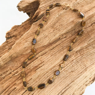 Cateye Rosary Necklace featuring Tigers Eye stones on a wooden background.