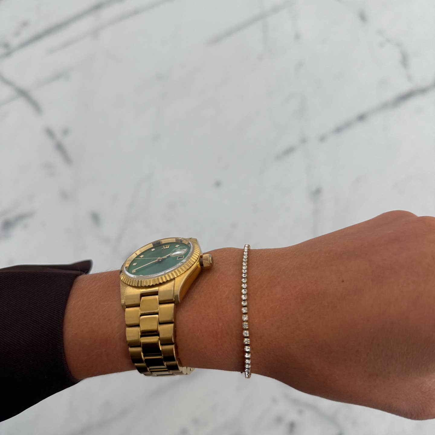 Gold watch on a wrist with a blurred background