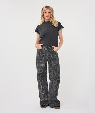 Leopard print denim trousers on a hanger, showcasing a bold pattern.