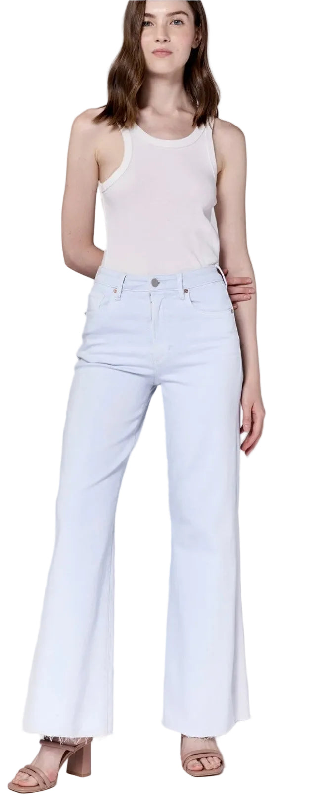 Woman wearing a white sleeveless top and light blue jeans on a plain background