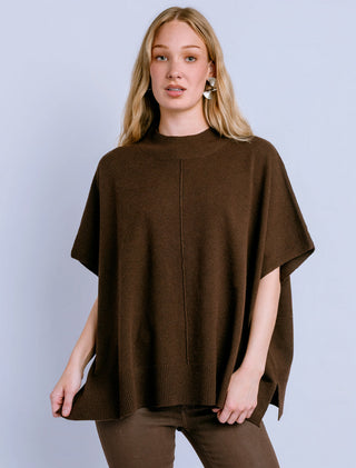 Oversized brown turtleneck sweater with center seam detail worn by a model.