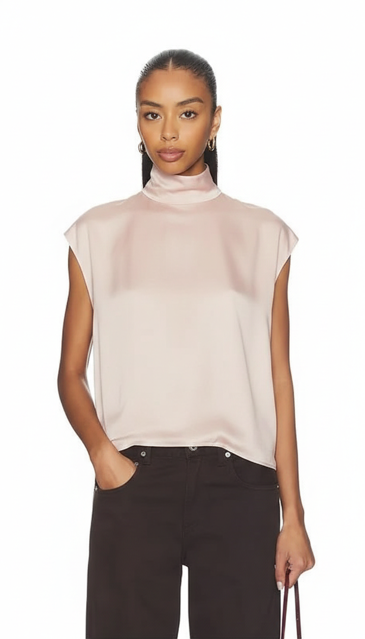 Woman wearing a light pink sleeveless top and black pants on a white background