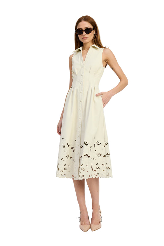 Woman wearing a sleeveless cream dress with floral patterns on a white background