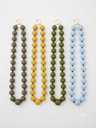 Four resin bead necklaces in olive green, mustard yellow, forest green, and light blue with gold-tone lobster clasps.