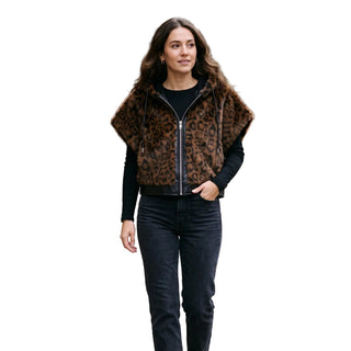 A sleeveless leopard faux fur vest with vegan leather trim and a drawstring hood, featuring a zip-front closure.