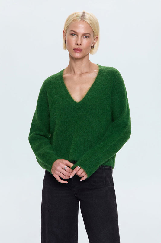 Woman wearing a green sweater against a light gray background
