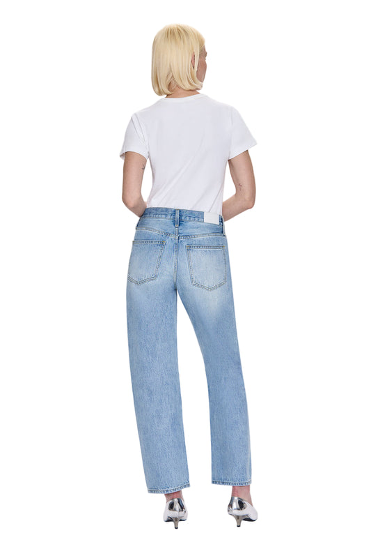 Person wearing light blue jeans and a white t-shirt on a white background