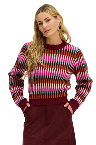 A model wearing a medium-weight Fair Isle knit sweater in pink multi with long sleeves.