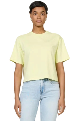 Person wearing a light yellow t-shirt and light blue jeans on a plain background