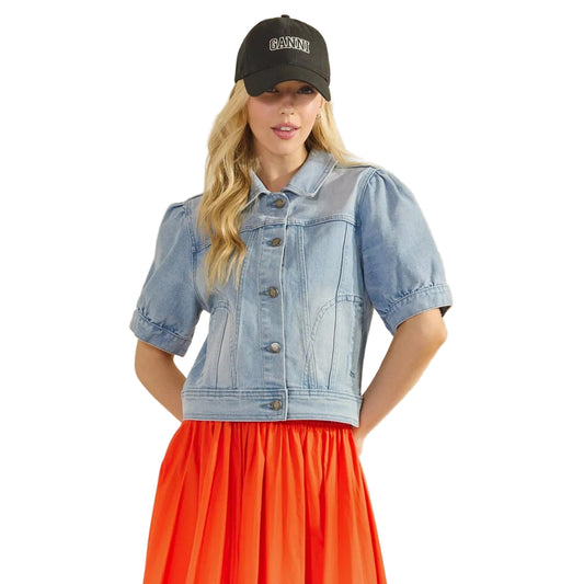 Woman wearing a denim jacket and red dress with a beige background