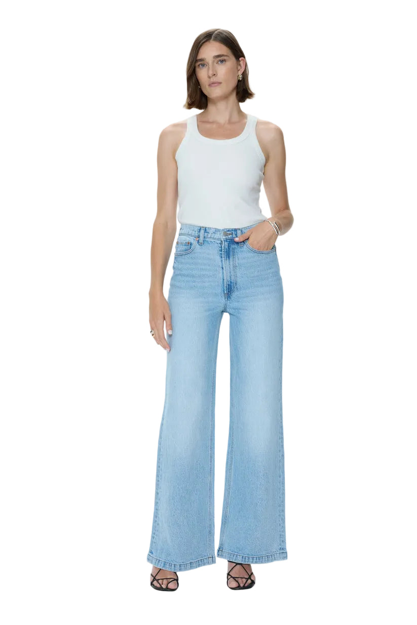 Woman wearing light blue jeans and a white top on a white background