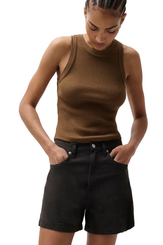 Woman wearing a brown tank top and black shorts on a plain background