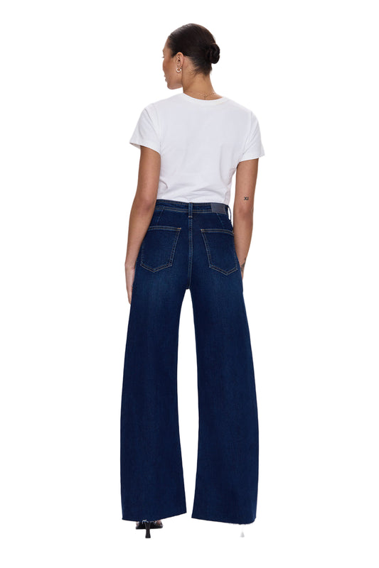 Person wearing blue jeans and a white t-shirt on a light gray background