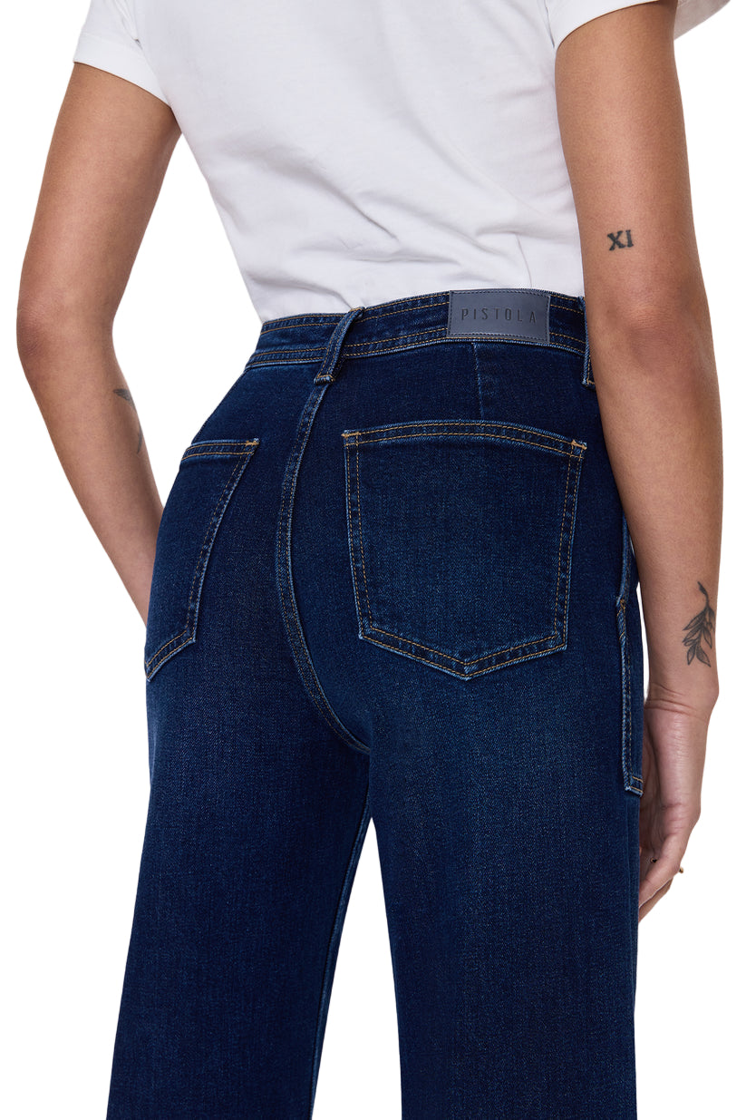 Person wearing dark blue jeans on a white background