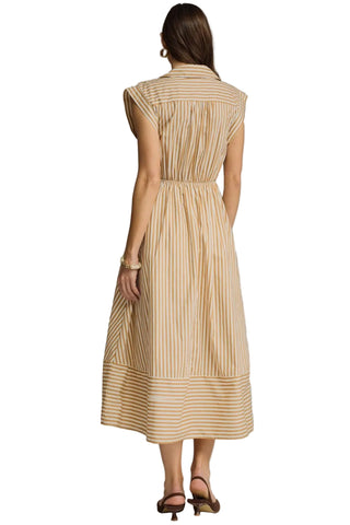 Woman wearing a beige striped dress against a gray background