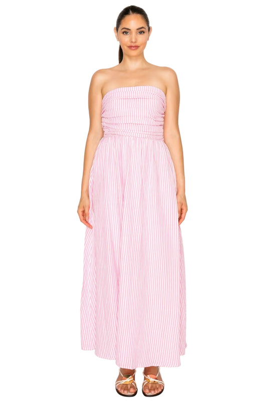 Woman wearing a pink strapless dress with white stripes on a white background